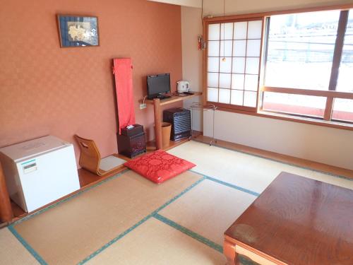 a living room with a table and a window at Oyado Matsubaya in Minakami