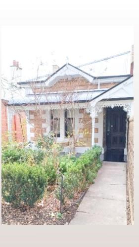 a brick house with a door and a sidewalk at HAVEN: Stunning Unley *history*location*charm 3bd in Unley