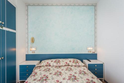 a bedroom with a bed with blue walls and blue cabinets at Hotel Raffaello in Bellaria-Igea Marina