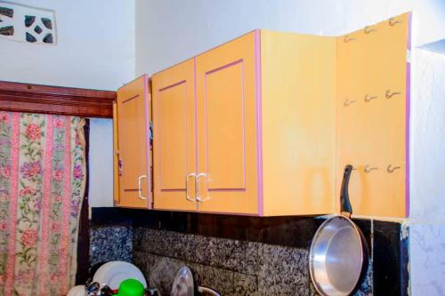 a kitchen with orange cabinets on the wall at Kigali Sunrise Villa in Kigali