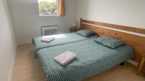 a bedroom with a bed with two pillows on it at Gîte du bosquet in Égletons