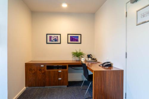 an office with a wooden desk and a chair at Cosmopolitan Hotel and Apartments in Melbourne