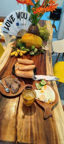 Una mesa de madera cubierta con verduras y otros alimentos. en DE MEKONG HOSTEL MY THO City, en Mỹ Tho