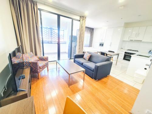 a living room with a tv and a couch and a table at Exodus Dandenong Apartment Hotel in Dandenong