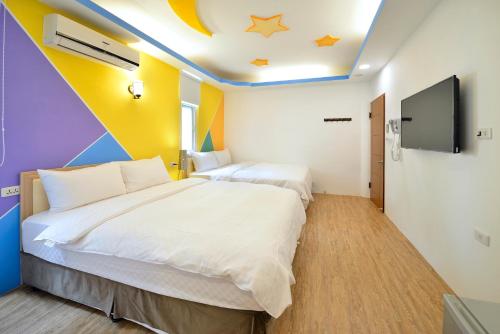 a bedroom with two beds and a flat screen tv at Kenting 166 in Kenting