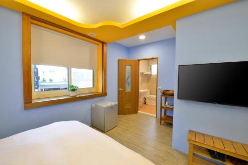 a bedroom with a flat screen tv on a wall at Kenting 166 in Kenting