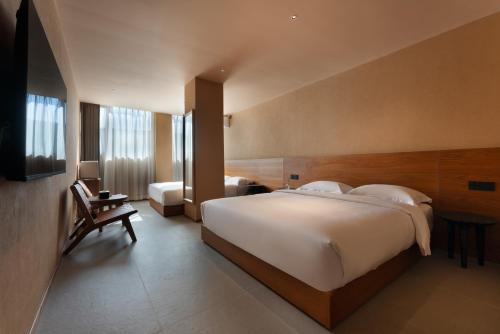 a bedroom with a large white bed and a chair at Roy Hotel-Tianya Town Store in Sanya