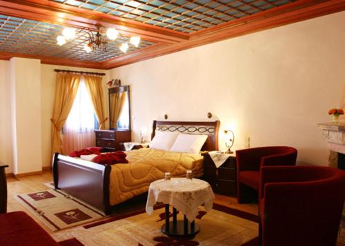 a bedroom with a bed and a table and chairs at Hotel Ladias in Monodendri