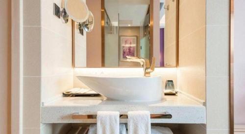 a bathroom with a sink and a mirror and towels at Lavande Hotel Beijing Fangshan Changyang Metro Station in Beijing