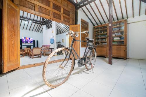 a bike parked in a room with a dining room at Omah Simbah Malioboro in Ngabean