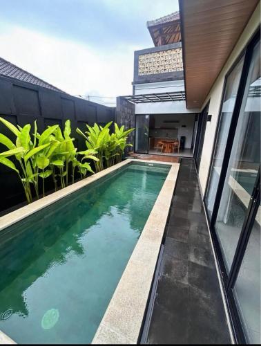 a swimming pool on the side of a house at Villa Teduh Canggu in Dalung