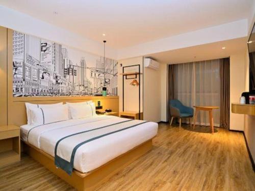 a hotel room with a large bed and a desk at City Comfort Inn Kunming High Speed Railway South Station Yongxin Harvard in Kunming