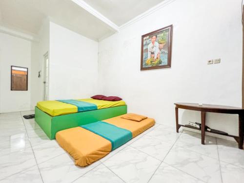 two beds in a room with a table at Omah Simbah Malioboro in Ngabean