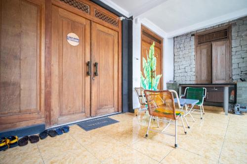 a room with two chairs and a wooden door at Omah Simbah Malioboro in Ngabean