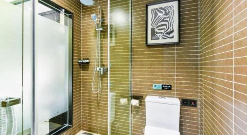 a bathroom with a glass shower and a toilet at Xana Hotelle Wuxi Railway Station Zhongshan Road in Wuxi