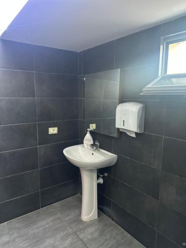 a bathroom with a white sink and a window at Bar Hotel Orgito in Lushnjë