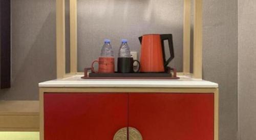 a counter with two bottles of water and a coffee maker at E-Cheng Hotel Yangjiang Baili Plaza in Yangjiang