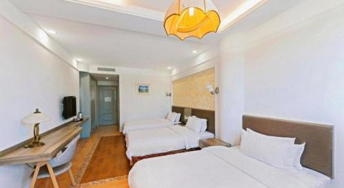 a hotel room with two beds and a desk at GreenTree Alliance Hotel Shanghai Baoshan District Meilan Lake Yueluo Road in Baoshan