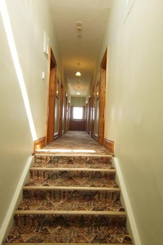an empty hallway with stairs in a building at Empire Hotel Backpackers in Oamaru