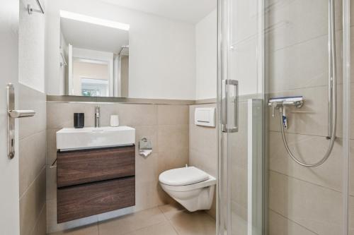 a bathroom with a toilet and a sink and a shower at UP&GREAT Apartments - Chic Urban Homes in Zürich