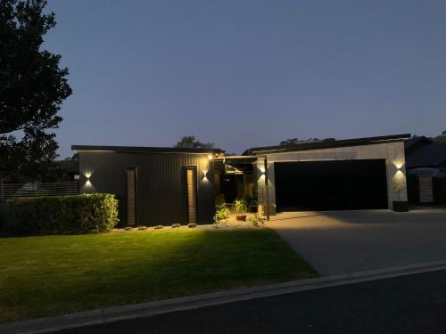 a house with lights on the side of it at Admiral Waters in Cooks Beach