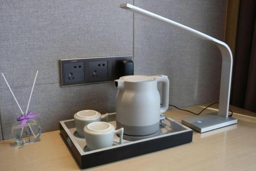 a counter with a coffee maker and two cups at Lavande Hotel Huizhou Shiwan in Huizhou