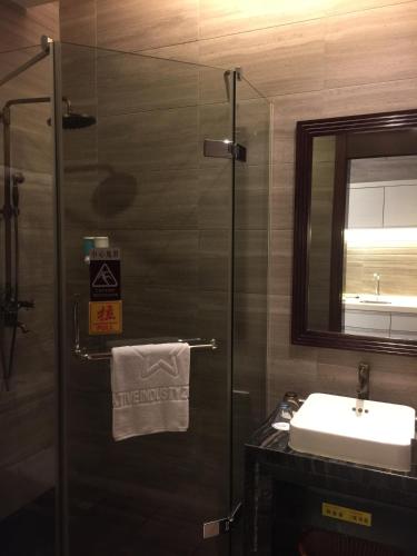 a bathroom with a shower and a sink and a mirror at Guangzhou Fangyuan Hotel - Free Shuttle Bus to Canton Fair Complex during 14th Oct to 3rd Nov in Guangzhou