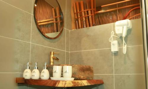 a bathroom with a mirror and a shelf with toothbrushes at Cat Ba Holiday Retreat in Cat Ba