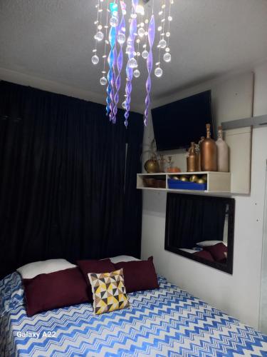a bedroom with a bed and a chandelier at apartamento cop30 in Ananindeua