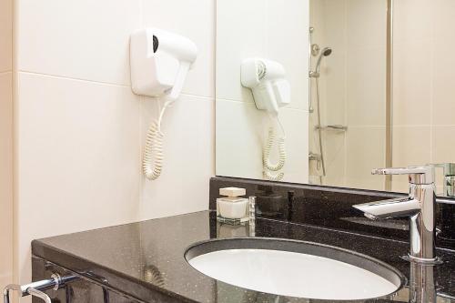 ドバイにあるIbis Deira Creekside Dubaiのバスルーム(洗面台、壁掛け電話2台付)