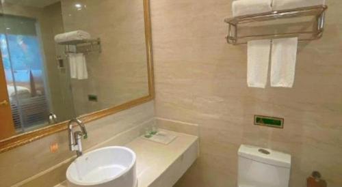 a bathroom with a sink and a mirror and a toilet at Vienna Hotel Guangdong Shantou South Bus Station in Shantou