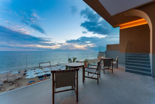 a balcony with tables and chairs and the beach at Roy Hotel-Tianya Town Store in Sanya