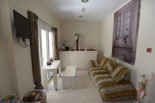 a living room with a couch and a tv at Fantastic Matala 2 in Matala