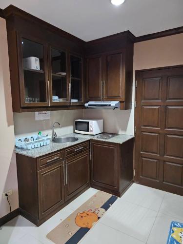 a kitchen with wooden cabinets and a sink and a microwave at วิวทะเล5 c in Ban Chek