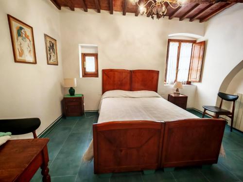 a bedroom with a wooden bed and a table and chairs at Le Corti - Agriturismo Olio e Vino in Lastra a Signa