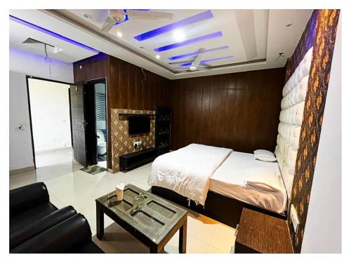 a bedroom with a bed and a couch and a table at Hotel Alitus Nangal in Nāngal