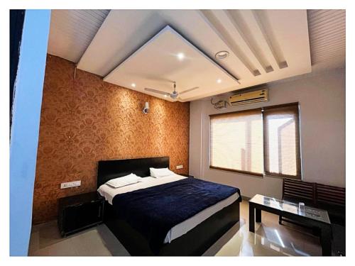 a bedroom with a bed with a blue comforter at Hotel Alitus Nangal in Nāngal
