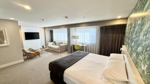 a hotel room with a bed and a couch at Pacific Hotel Cairns in Cairns