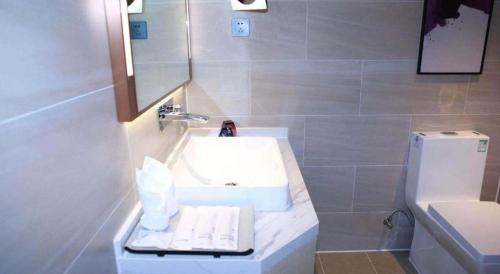 a bathroom with a white sink and a mirror at Lavande Hotel Shenzhen East Gate Wanxiang City Guomao Metro Statipn in Shenzhen