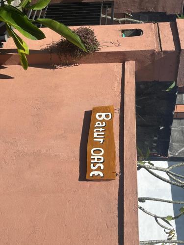 a sign on the side of a wall that says welcome at Batur OASE in Kubupenlokan