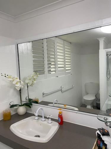 a bathroom with a sink and a large mirror at Horizons 1 in Bargara