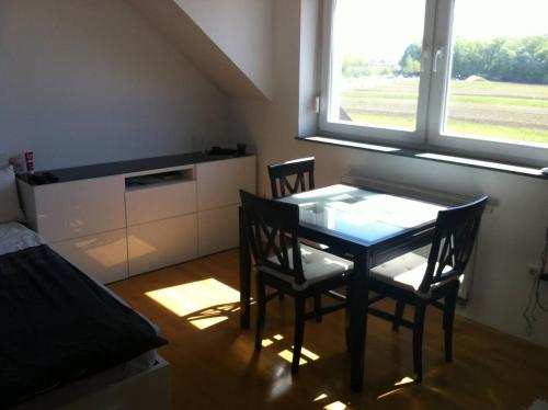 a dining room with a table and chairs and a window at Andro studio apartment in Ljubljana