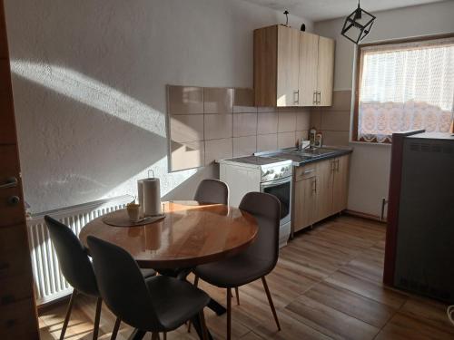 a small kitchen with a wooden table and chairs at Jovan in Šipovo