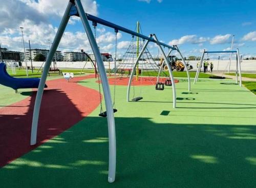 an empty playground with empty swings at White Bear Apartment in Suwałki