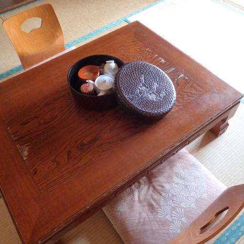 a wooden table with a bowl of food on it at Oyado Matsubaya in Minakami
