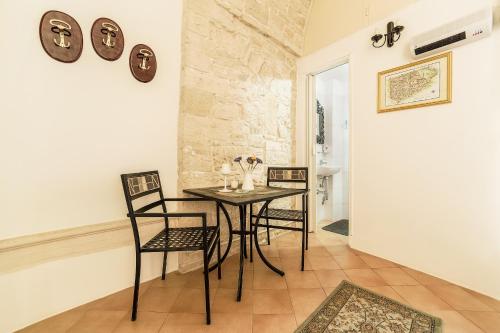 uma sala de jantar com uma mesa e duas cadeiras em La Torre Storica em Bitonto