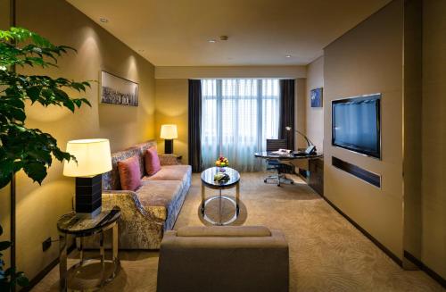 a living room with a couch and a tv at Baiyun Hotel Guangzhou in Guangzhou