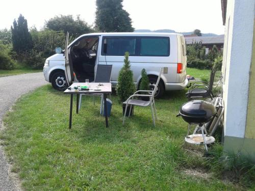 a white van parked in the grass next to a grill at NF Alpenvorland 