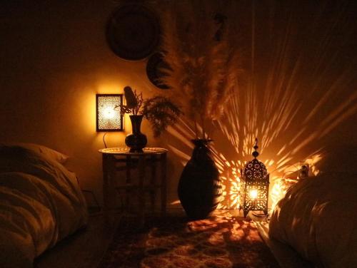 a room with a lamp and two vases on a table at yaora in Kurashiki