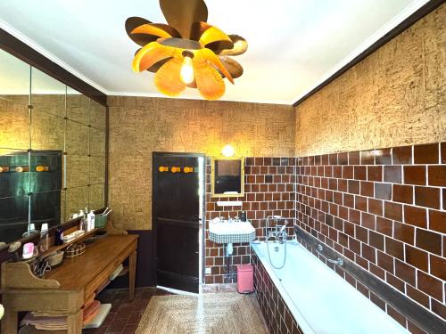 a bathroom with a tub and a sink and a ceiling fan at Le Manoir familial du Quesnot, idéal familles et amis in Lessard-et-le-Chêne